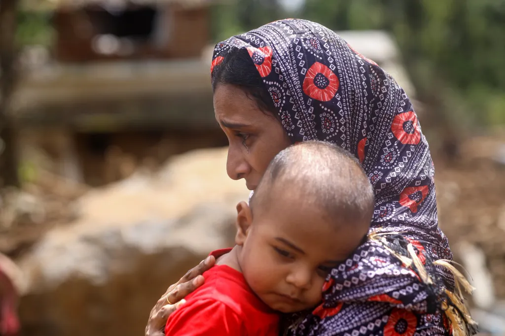 ദുരിതാശ്വാസ ക്യാമ്പിൽ നിന്ന് വീട് നിന്നിരുന്ന പ്രദേശത്തേക്ക് വന്ന ഹയറുന്നിസയും കുഞ്ഞും. വീടുകൾക്കിടയിൽ നിന്നും കുഞ്ഞുങ്ങളുടെ കളിപ്പാട്ടങ്ങളുടെയും, പാത്രങ്ങളുടെയും അവശിഷ്ടങ്ങൾ മാത്രമാണ് തറവാട് വീട്ടിൽ നിന്നും അവർക്ക് കണ്ടെടുക്കാനായത്. ക്യാമ്പിൽ നിന്നും പതിനൊന്നാം ദിവസമാണ് അവർ വീട് നിന്ന് സ്ഥലത്തെ കാണുവാൻ തിരികെ വന്നത്. 