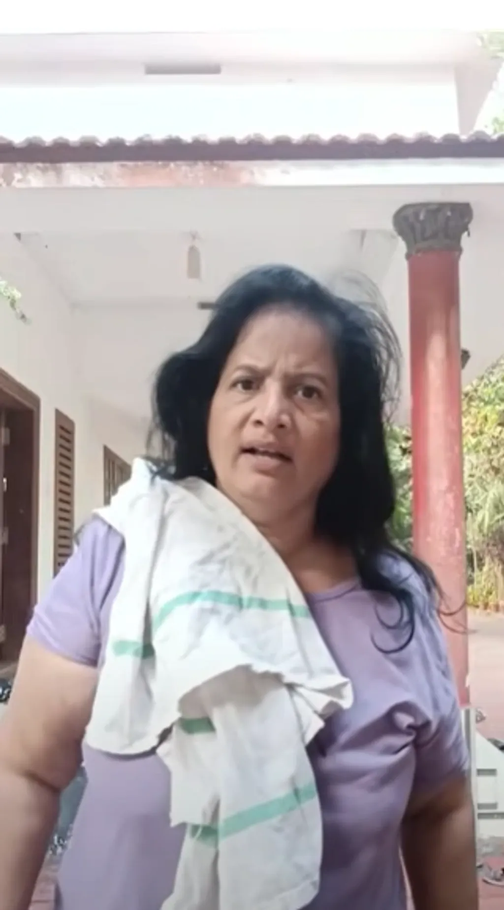 സ്വന്തം വീടിനുമുന്നിൽ ‘കുളി സമരം' നടത്തുന്ന കണ്ണൂർ ഗവ. എഞ്ചിനീയറിങ് കോളേജ് ജീവനക്കാരിയായ ശ്രീലത.