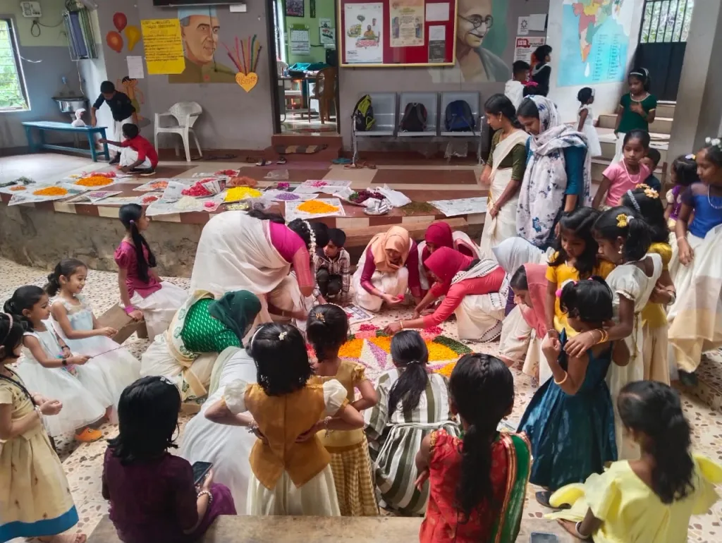 മുണ്ടക്കൈ സ്‌കൂളിലെ ഓണാഘോഷം, സ്‌കൂൾ നടുമുറ്റത്ത് രക്ഷിതാക്കളും അധ്യാപകരും ചേര്‍ന്ന് പൂക്കളമിടുന്നു