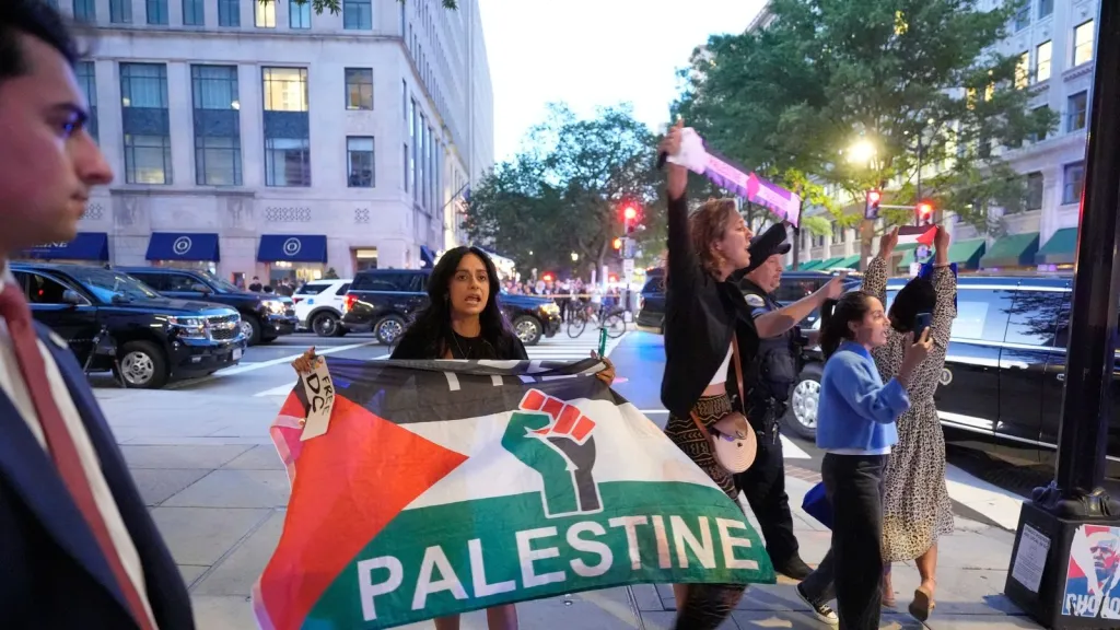 വാഷിംഗ്ടണിലെ റെസ്റ്റോറന്റിൽ അത്താഴം കഴിക്കാനെത്തിയ പ്രസിഡന്റ് ട്രംപിനു നേരെ പലസ്തീൻ പതാകയുടെ നിറങ്ങളിലുള്ള സ്കാർഫ് വീശി പ്രതിഷേധിക്കുന്നു.