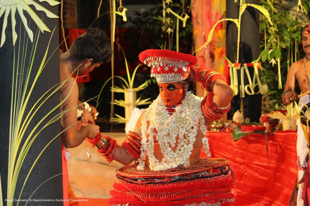  പഴയ തലമുറയിലെ അന്തിത്തിരിയൻ അഥവാ കോമരങ്ങൾ പുതിയ തലമുറയിലെ കുട്ടികളെയും അവരുടെ പ്രായത്തിലുള്ള മറ്റുള്ളവരെയും നേരിൽ കാണുന്നതിനും പുതിയ തലമുറ പഴയ തലമുറയിലെ മനുഷ്യരുടെ ജീവിതാവസ്ഥ കാണുന്നതിനുമുള്ള സന്ദർഭങ്ങൾ ഇതുവഴി ഒരുങ്ങുന്നു. (തെയ്യവേഷത്തിൽ പ്രൊഫ. രാജേഷ് കോമത്ത്)