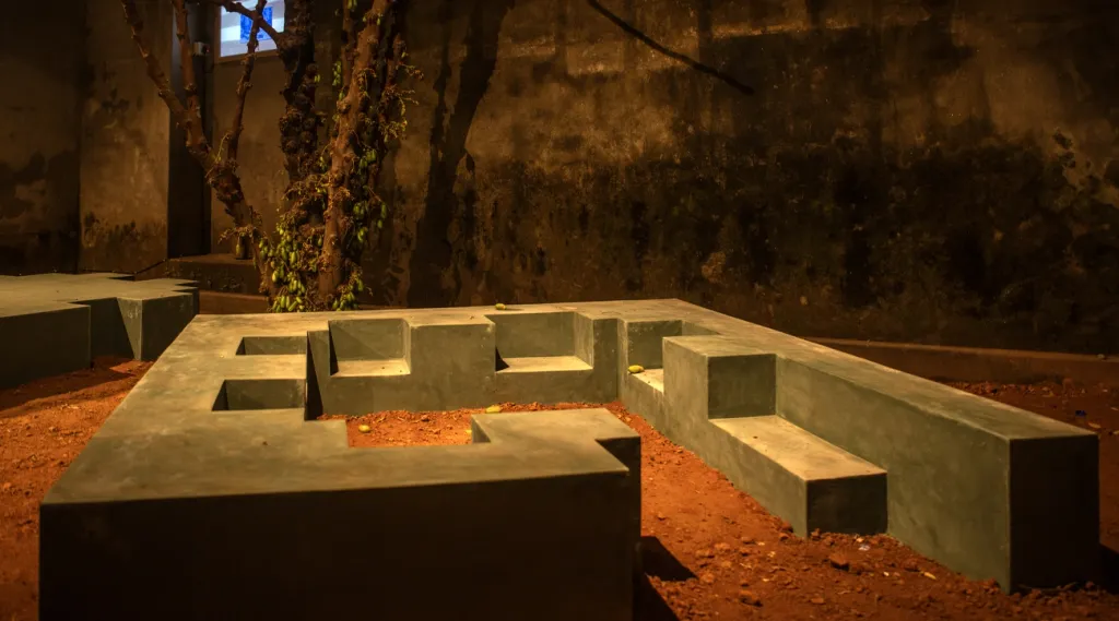 ദീമ സ്രൂജിയുടെ  അടിത്തറകൾ  എന്ന സൈറ്റ്സ്പെസിഫിക് ഇൻസ്റ്റലേഷൻ. ‘റെസ്റ്റിംഗ് ഇൻ ദ ഡസ്റ്റ്’ മണ്ണിനടിയിൽ സ്തബ്ധമായി കിടക്കുന്ന സ്മൃതികളെയും അവശിഷ്ടങ്ങളെയും ഒരു ആംഫിബിയൻ ഇടനിലയായി അവതരിപ്പിക്കുന്നു.