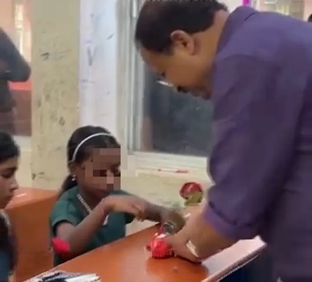 കട്ടേല ഗവ. ട്രൈബൽ എൽ പി സ്കൂളിലെ പ്രവേശനോത്സവത്തിൽ കുട്ടികൾക്ക് മിഠായി കയ്യിൽ കൊടുക്കാതെ മേശയിൽ വിതറിയിടുന്ന ബിജെപി എംഎൽഎ വി. മുരളീധരൻ.