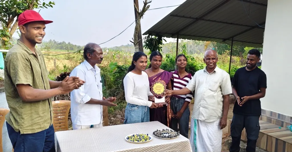 ആര്യക്ക് എം. ഗീതാനന്ദൻ ഉപഹാരം നൽകുന്നു. ആര്യയുടെ അച്ഛൻ വേലായുധൻ സമീപം